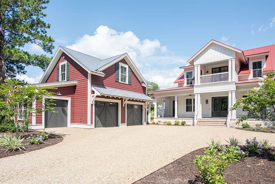 white and red two story home with garage